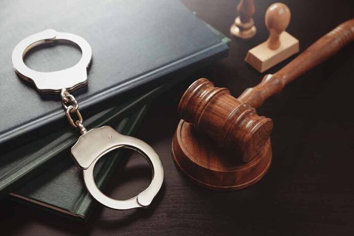 Gavel and handcuffs on a desk.