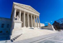 Supreme Court building with columns and statues.