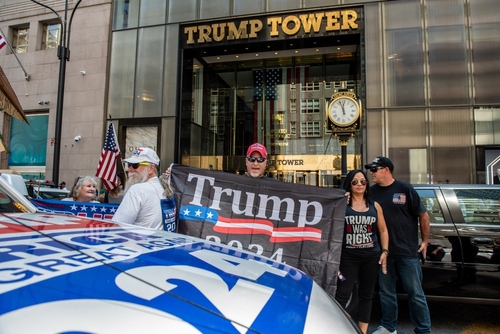 People holding Trump 2024 banner outside Trump Tower.