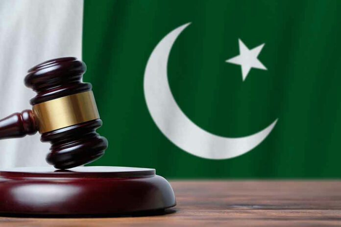 Gavel with Pakistan flag in the background.