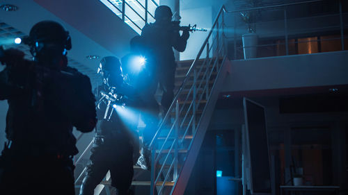 shutterstock1701604495jpg Tactical police team ascending a stairwell with weapons and flashlights