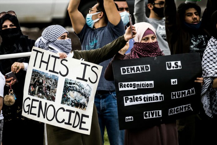 shutterstock1973748050jpg Protesters holding signs at a rally