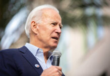 Jill Biden’s SHOCKING Debate Night Revelation… A man in a suit speaking into a microphone at an outdoor event