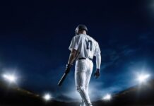 MLB Exec’s SHOCKING Anti-Christian Bias Leaked! A baseball player standing on the field at night, holding a bat