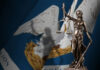 Lady Justice statue with Louisiana state flag background.