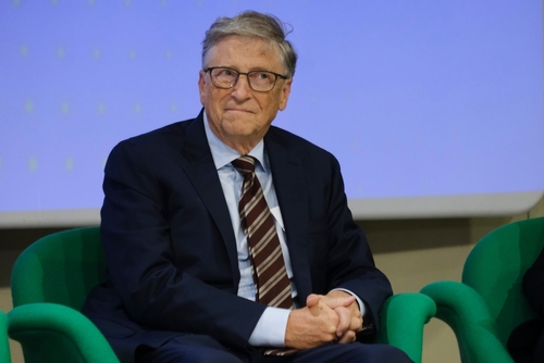 Former,Microsoft,Ceo,,Bill,Gates,During,The,Launch,Of,A A man in a suit sitting on a green chair during a conference
