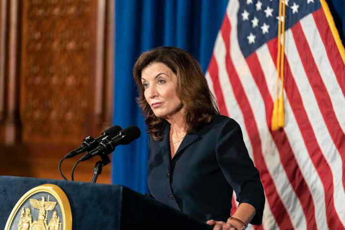 2023461065 Woman speaking at podium with American flag backdrop.