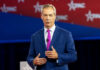 Man in a blue suit speaking on stage