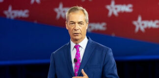 Man in a blue suit speaking on stage