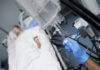 Patient in hospital bed with IV drip close-up.