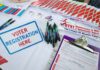 FBI Memo Sparks China Vote Plot Uproar Voter registration table with forms, pens, and informational materials
