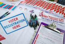 FBI Memo Sparks China Vote Plot Uproar Voter registration table with forms, pens, and informational materials