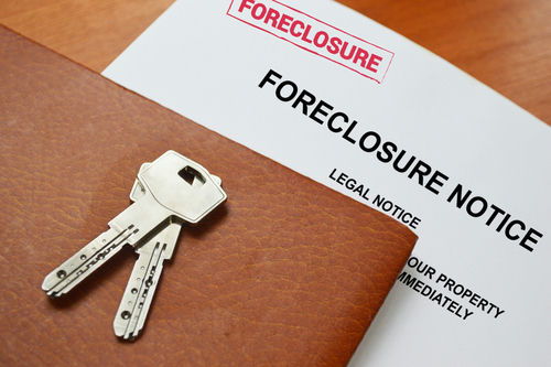 shutterstock_1898703490 Keys on a foreclosure notice document and leather folder.