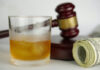 California Targets Hidden Food Additives A glass of whiskey next to a gavel and rolled money