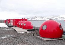 Red dome shelters at a polar research station by the sea