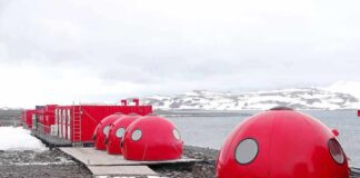 Red dome shelters at a polar research station by the sea