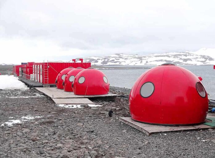 Red dome shelters at a polar research station by the sea