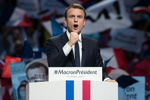 shutterstock_623078429 Emmanuel Macron at a campaign rally podium.